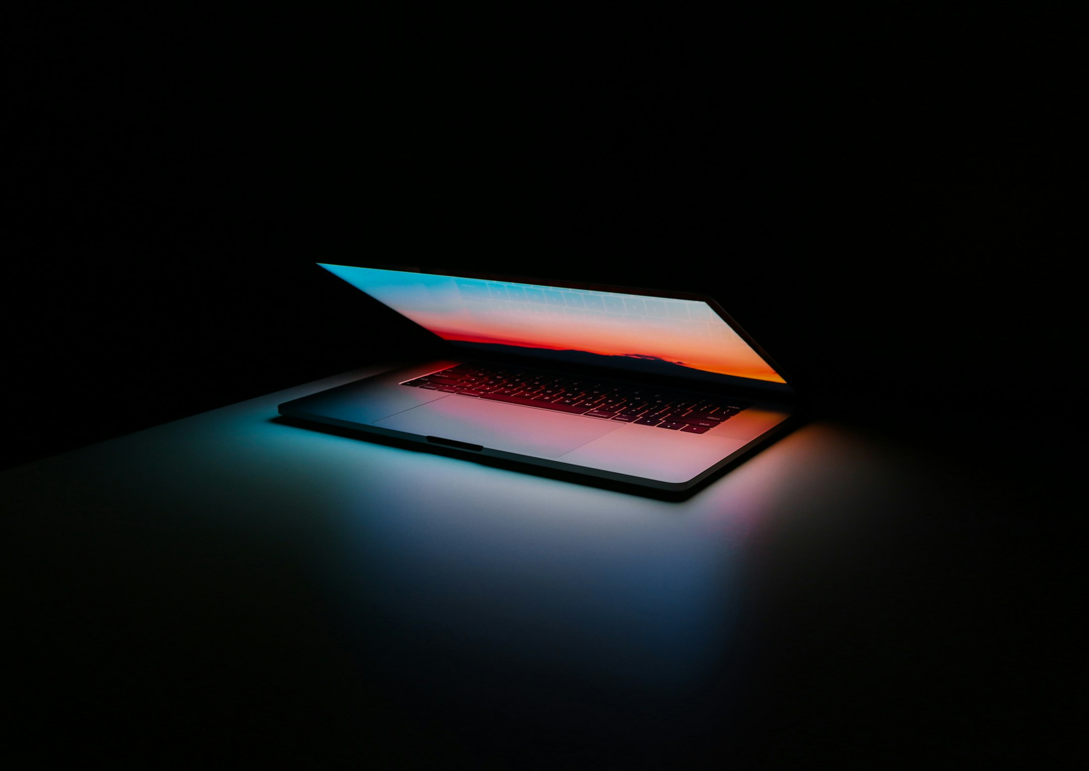 Laptop semiaperto che emana luce nel buio
